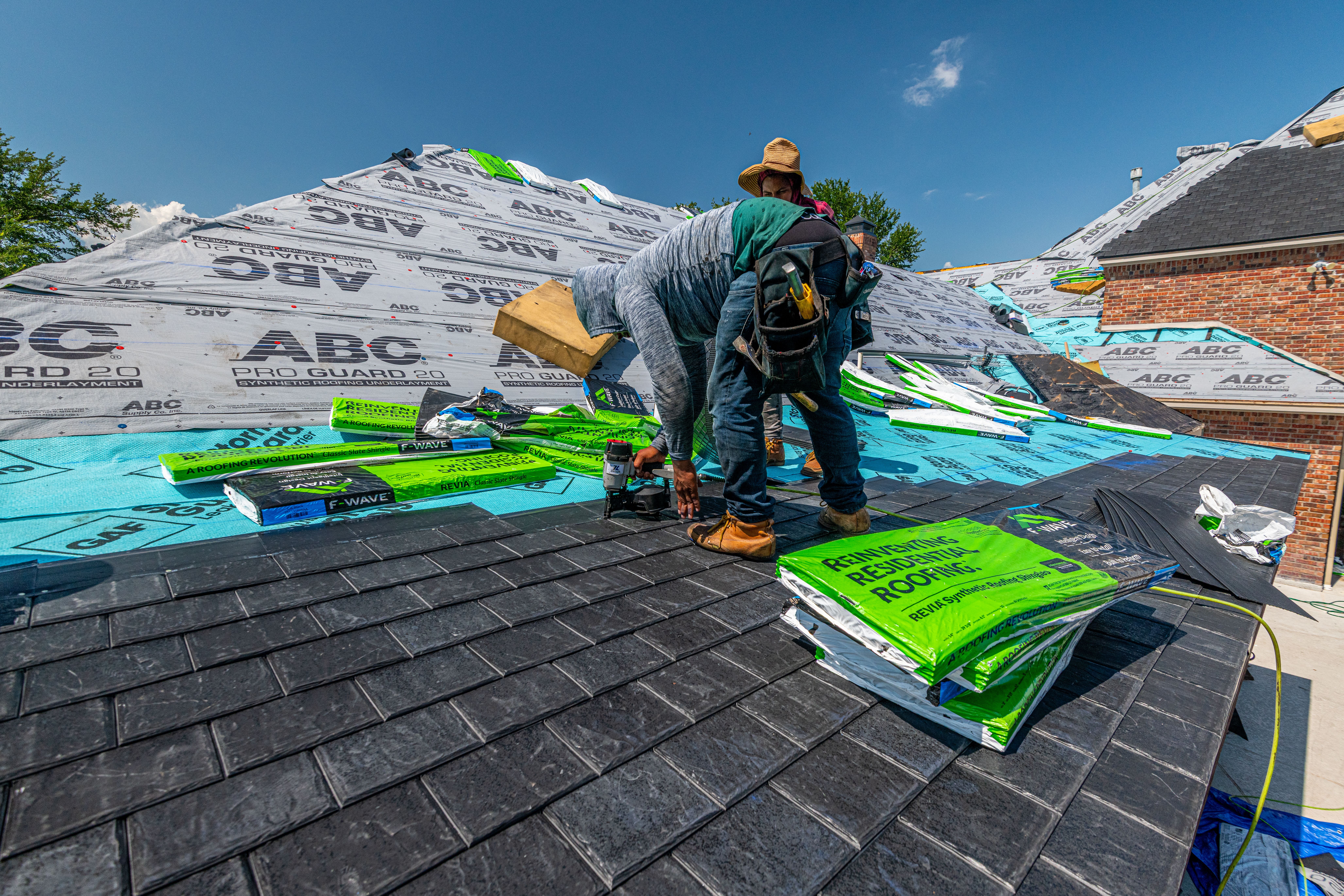 Roofer repairing damaged shingles on a residential roof